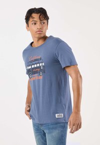Blue cotton t-shirt with short sleeves, round neckline, featuring a graphic print of a vintage van and text in orange and black.