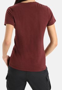 Burgundské tričko s krátkým rukávem vyrobené z měkké tkaniny, s kulatým výstřihem a mírně přiléhavým střihem, bez viditelných log nebo vzorů.