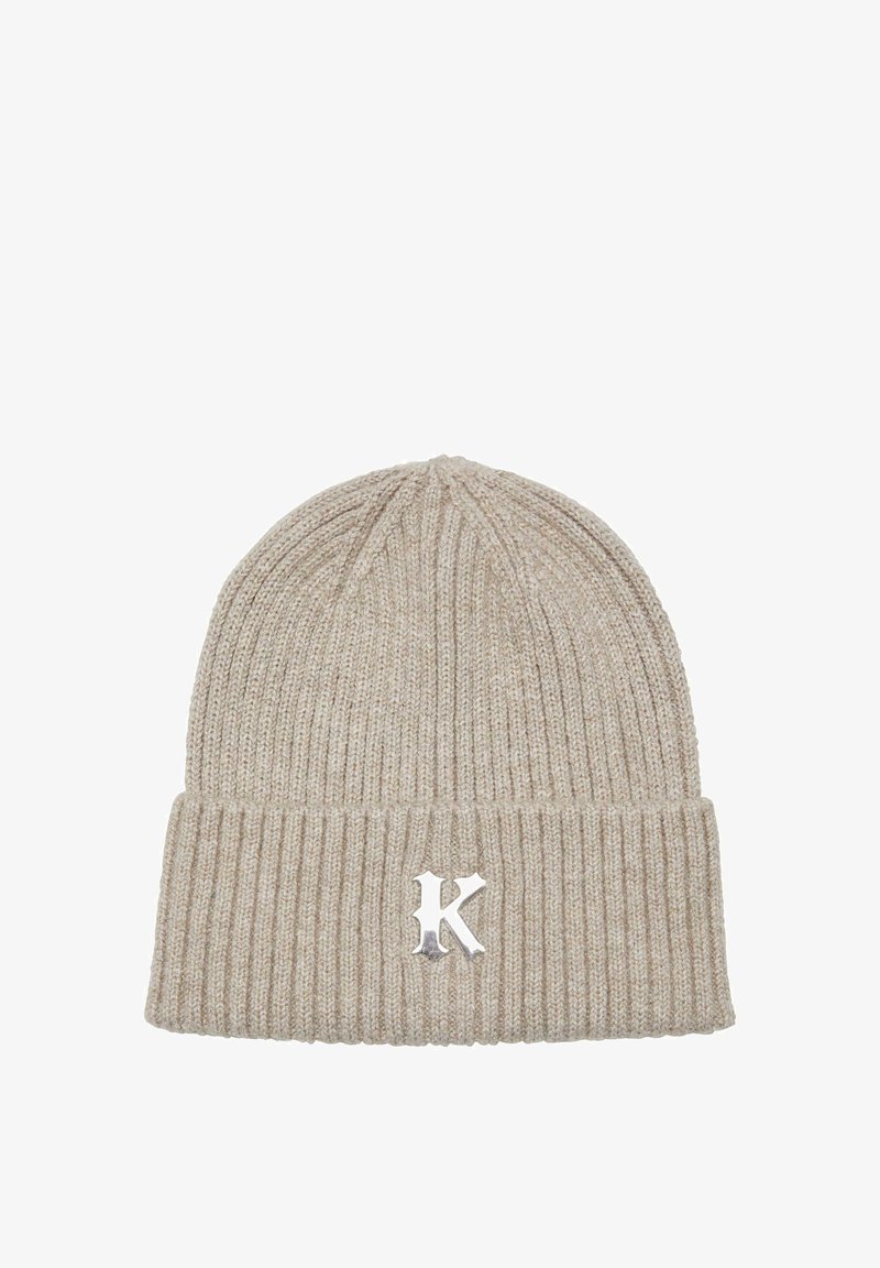 Beige knitted beanie with a ribbed texture, featuring a folded cuff and a silver "K" logo accent. Made from soft, stretchy material.