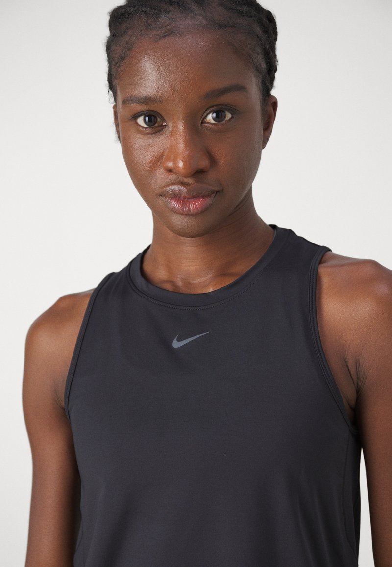 Schwarzes Nike Tanktop mit rundem Ausschnitt, ärmellosem Design und einem kleinen grauen Logo auf der Brust. Glattes Gewebe mit leichtem Glanz.