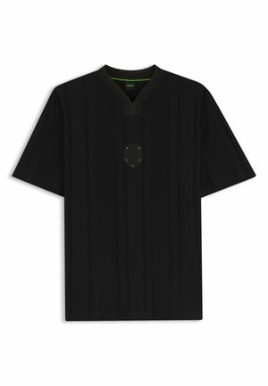 Chemise noire à manches courtes avec col en V, petite écusson poitrine avec des étoiles et détail subtil vert à l'intérieur du col.