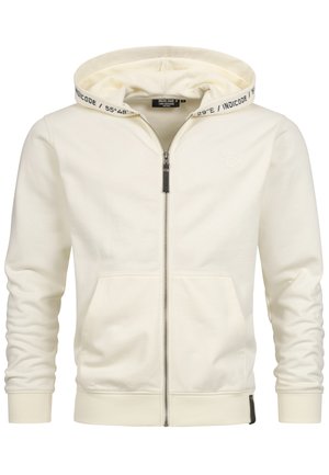 Crème kleurige zip-up hoodie van zachte stof. Voorzien van een trekkoord kap met bedrukte logo, voorzakken en geribbelde manchetten. Subtiele branding op de borst.