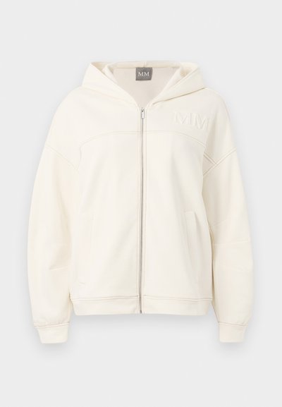 Cream-colored zip-up hoodie made of soft fabric featuring a hood, ribbed cuffs, and kangaroo pockets. Embroidered "MM" logo on chest.