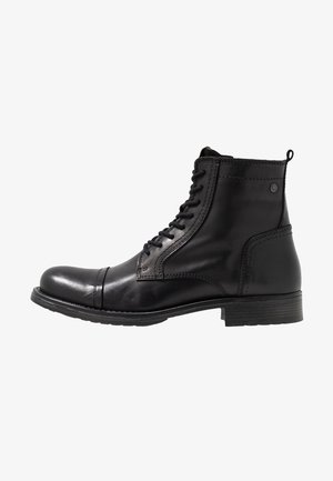 Botas de couro pretas até ao tornozelo com biqueira arredondada, atacadores à frente, acabamentos texturizados e um salto baixo e grosso.