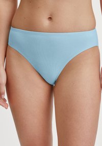 Helleblaue Unterwäsche aus einem glatten, dehnbaren Stoff. Sie hat einen tief sitzenden Bund und ein minimalistisches Design, ohne sichtbare Muster oder Beschläge.