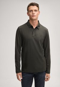 Polo a maniche lunghe di colore verde scuro con colletto, dotato di tre bottoni e un piccolo logo ricamato sul petto. Tessuto in morbido misto cotone.