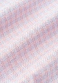 Tissu doux avec un motif à carreaux rose clair et bleu pâle, montrant une texture tissée fine et des plis délicats.