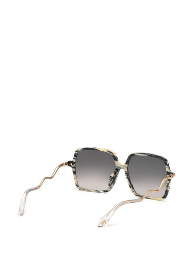 Lunettes de soleil carrées avec montures marbrées noires et beiges, verres dégradés foncés, et branches métalliques dorées ondulées se terminant par des embouts en plastique transparent.