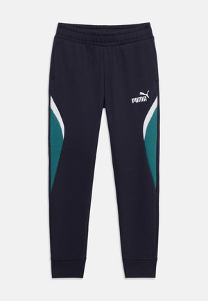 Pantalon de survêtement Puma bleu marine avec taille élastique, panneaux latéraux turquoise et blancs, poches avant, et logo Puma sur la partie supérieure de la jambe gauche.
