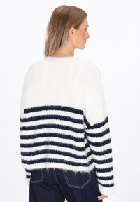 Gestreifter Pullover in Weiß und Marineblau mit einer flauschigen Textur. Verfügt über einen runden Halsausschnitt und überschnittene Schultern, mit einem entspannten Schnitt und gerippten Bündchen.