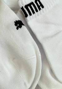 Weiße Baumwollsocken mit schwarzem "ima"-Logo und dekorativer Naht. Mit gerippten Abschlüssen und nahtlosem Zehenbereich.