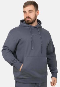 Grijze hoodie van zacht materiaal met een voorkant zak, trekkoorden en subtiele logo borduursels op de borst en mouw.