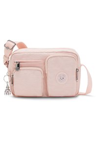 Różowa torba na ramię z teksturowanego materiału, z dwoma przednimi kieszeniami, okrągłą naszywką z logo oraz srebrną zawieszką w formie breloka.