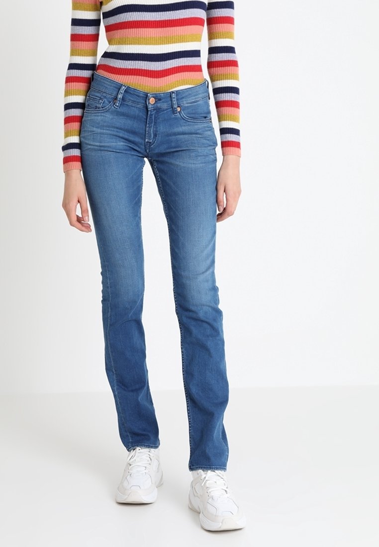 Vaqueros de denim azul con corte ajustado, cintura media y un ligero desgastado. Presentan un diseño clásico de cinco bolsillos y cierre de botón.