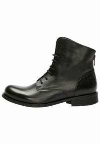Botas de tobillo de cuero negro con un acabado suave, puntera redonda, cordones en la parte frontal y cremallera lateral. Suela plana y acentos de diseño minimalista.