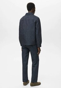 Giacca e pantaloni in denim scuro, caratterizzati da un design classico, con chiusura a bottoni, maniche lunghe e una tasca sul petto. Tessuto strutturato.