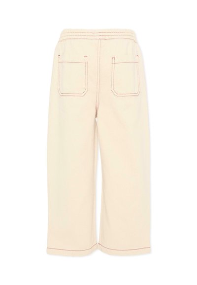 Pantalon large crème avec taille élastique et deux poches plaquées à l'arrière, présentant une couture contrastée rouge.