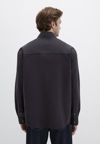 Dunkelgraues Hemd mit Kragen, langen Ärmeln und glatter Textur. Verfügt über Knöpfe an den Manschetten und ein klassisches Schnittdesign.