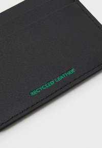 Μαύρος θήκης καρτών από ανακυκλωμένο δέρμα με υφή, που διαθέτει πολλαπλές θήκες και πράσινο κείμενο "ΑΝΑΚΥΚΛΩΜΕΝΟ ΔΕΡΜΑ".