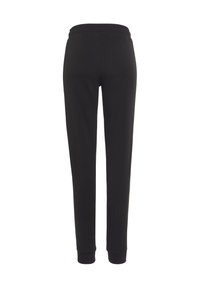 Schwarze Sweatpants mit elastischem Bund, schmal zulaufenden Beinen und gerippten Bündchen. Hergestellt aus weichem, dehnbarem Material für hohen Tragekomfort.