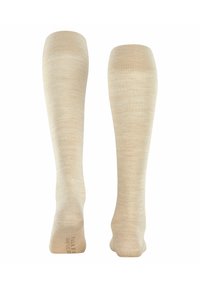 Hellbeige kniehohe Socken mit glatter Textur, subtilen Mustervariationen und verstärkten Zehen. Keine sichtbaren Marken oder Akzente.