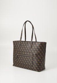 Black tote bag made of textured material with a repeating logo pattern in gold. Features long handles and a zippered front pocket.