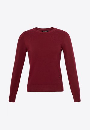 Bordeauxfarbenes Langarmshirt aus Strickstoff. Mit Rundhalsausschnitt und geripptem Saum und Bündchen. Dezenter Logoakzent am Saum.