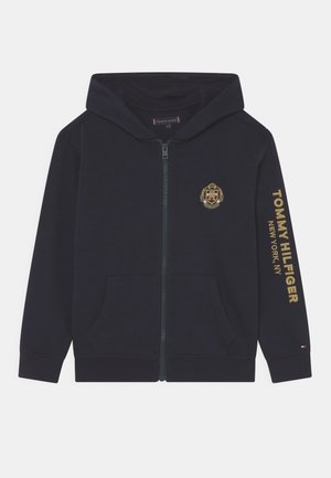 Czarna bluza z kapturem na zamek z złotym herbem Tommy Hilfiger na piersi oraz złotym napisem "Tommy Hilfiger New York, NY" na prawej rękawie.