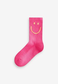 Rosa Baumwollsocke mit gerippter Textur, versehen mit einem gelben Smiley-Gesicht auf dem oberen Teil. Glatte Oberfläche, Knöchellänge.