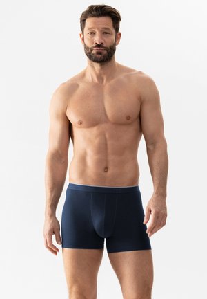 Marineblaue Boxershorts aus weichem Stoff, mit einem kontrastierenden hellgrauen Bund, der mit dem Markennamen geprägt ist.