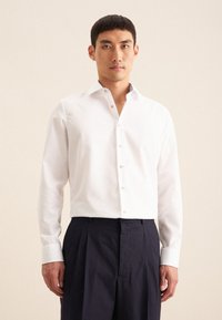 Witte blouse met lange mouwen en een notched kraag, voorzien van lichtbeige knopen, gecombineerd met marineblauwe plooibroek. Gladde katoenstof, aansluitend ontwerp.