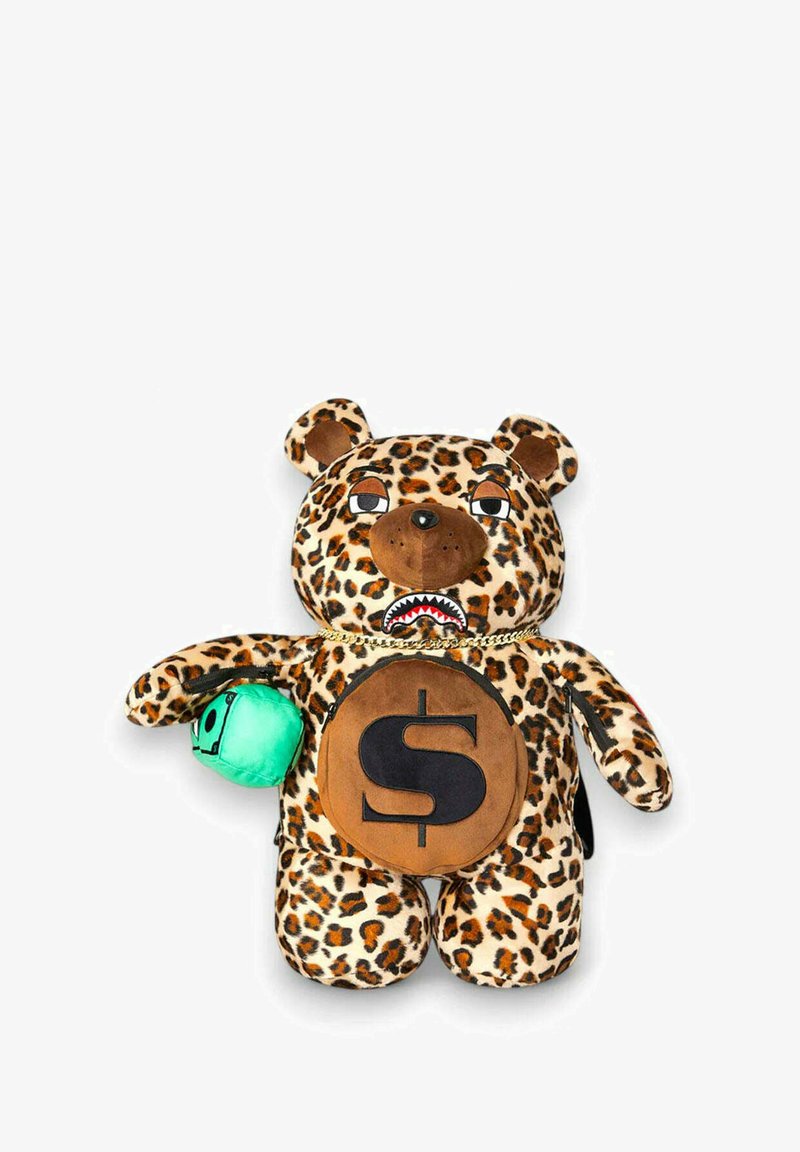 Orso di peluche maculato leopardato con un simbolo del dollaro marrone sulla pancia, accenti neri e un piccolo accessorio verde nella zampa. Presenta occhi espressivi.