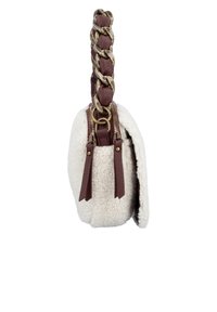 Vue de côté d'un sac à main en shearling blanc avec des tirettes de fermeture éclair en cuir marron et une bandoulière en cuir tressé.