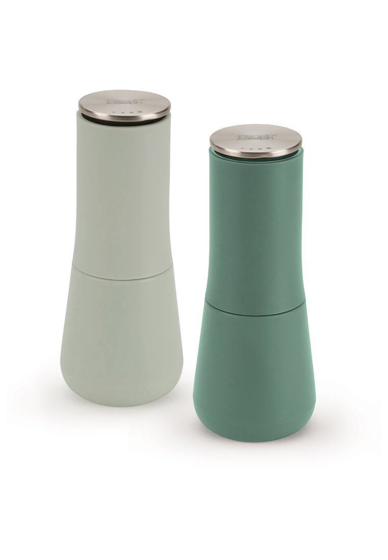 Hoge, moderne zout- en pepermolens met een matte lichtgroene en teal kleur en roestvrijstalen toppen, zij aan zij geplaatst op een witte achtergrond.