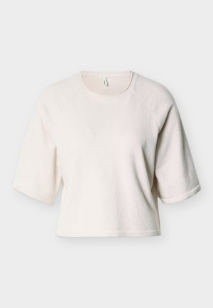 Lys beige kort sweatshirt laget av mykt, teksturert stoff. Har korte ermer og ribbestrikket detalj rundt halsen og nederkant.
