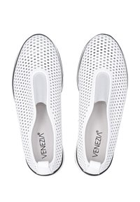 Bílé slip-on boty s perforovaným svrškem pro prodyšnost, elastickými bočními akcenty a černou podrážkou. Značka viditelná na stélce.
