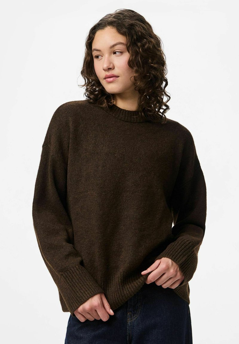 Brown knitted sweater with a round neck, ribbed cuffs, and hem. Features a relaxed fit and textured fabric for warmth.
