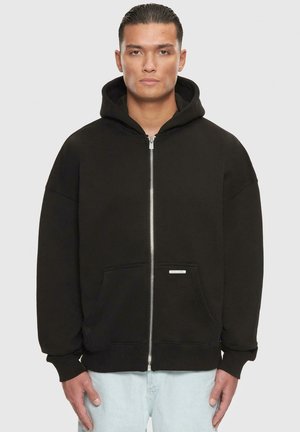 Black zip-up hoodie made of cotton blend. Features a hood, front pockets, and ribbed cuffs. Simple design with no patterns or additional hardware.