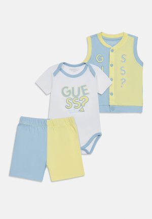 Kolmekomponentne beebiriiete komplekt siniste ja kollaste värviplokkidega, sisaldades pükse, lühikeste varrukatega bodid "GUESS?" tekstiga ning varrukateta nööpidega vest.
