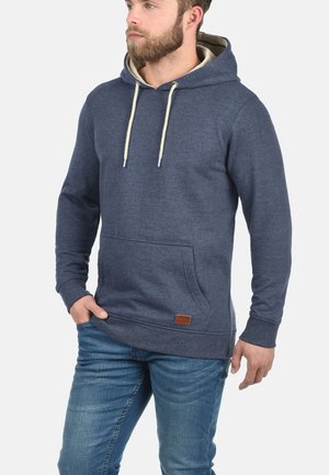 Hooded sweatshirt in dark blue fabric, featuring a front pocket, cream drawstrings, and a textured finish with a small leather logo patch.