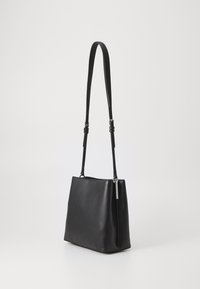 Borsa a spalla in finta pelle nera con tracolla regolabile. Forma rettangolare, texture liscia e design minimalista; include un sottile accento metallico.