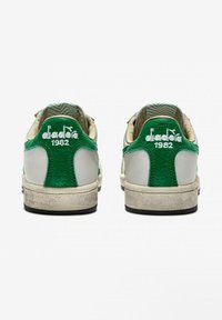 Sneaker verde e bianco con tomaia in pelle testurizzata, dettagli a contrasto, logo e suola in gomma usurata.