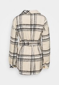 Krémová a černá kostkovaná fleecová bunda s dlouhými rukávy, zapínáním na knoflíky a odpovídajícím páskem ze stejného materiálu v pase, zobrazená zezadu.