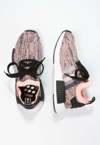 Pair of pink and black patterned athletic shoes with black laces and white cushioned soles, shown from top and side views on white background.