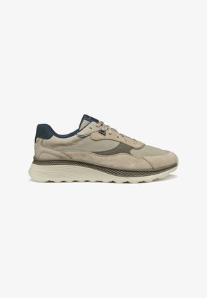 Sneaker beige con materiali in rete e camoscio. Presentano una suola testurizzata, accenti blu scuro e un design a punta arrotondata.