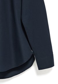 Navyblauwe katoenen shirt met een gebogen zoom, lange mouwen en een zijschuif. Beschikt over een soepele textuur en eenvoudige stikdetails.