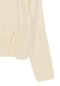 Maglione knitted color crema con orlo e polsini a costine, caratterizzato da spacchi laterali per aumentare la mobilità e una texture morbida.