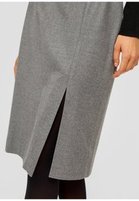 Grijze wollen rok met een zijsplits, een zachte textuur, een knielange snit en subtiele stiksels. Gekocht met zwarte maillot.