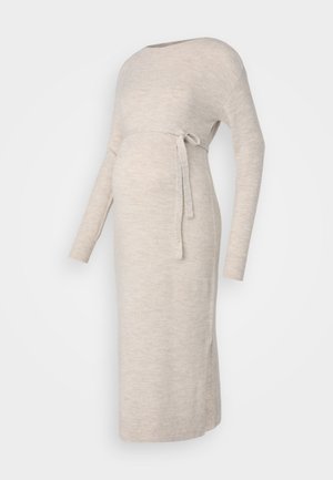 Stickad gravidklänning i ljusbeige med långa ärmar, båtformad halsringning och ett knytbälte i midjan, med sidofunktioner för enkel rörelse.