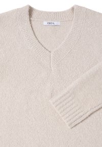 V-Ausschnitt-Cremepullover aus weichem, strukturiertem Stoff. Mit gerippten Bündchen und einem einfachen Etikett, das am Hals angenäht ist.